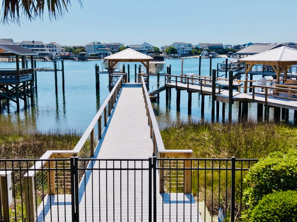 Long composite walkway with gated entry leading to covered pier