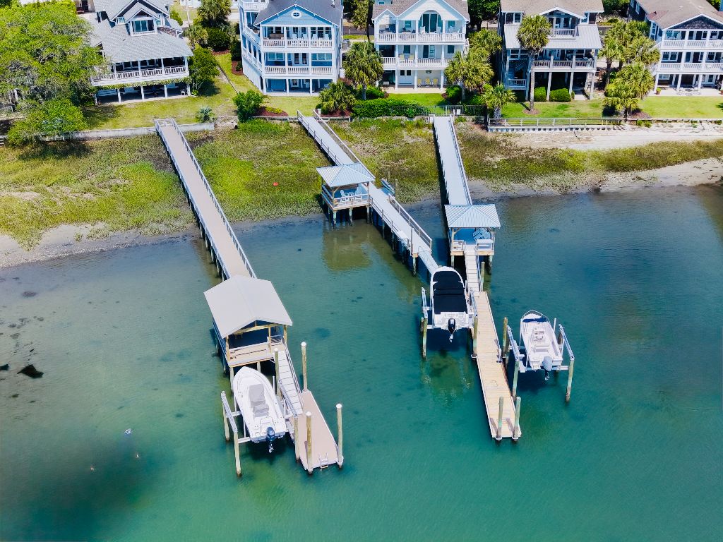 Aerial view of dual residential docks with covered boathouses and boat lifts