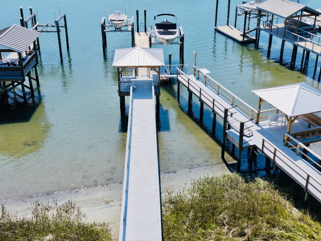 Aerial view of long composite walkway leading to covered gazebo with boat lift