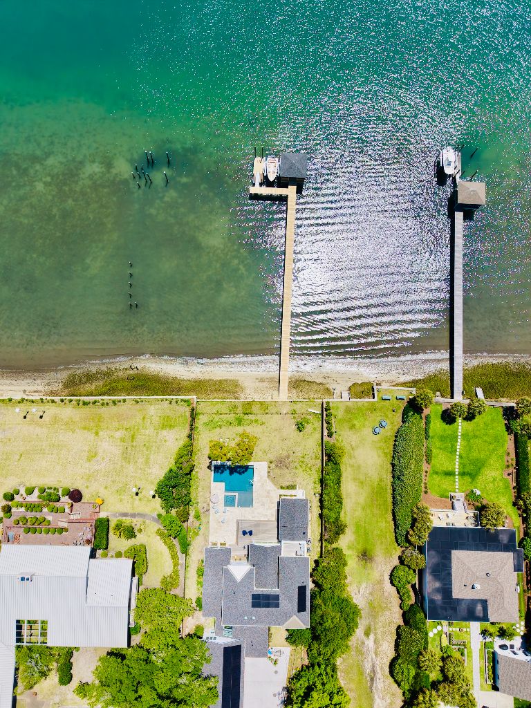 Aerial view of waterfront properties with custom docks and piers along the coastline